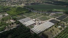 5K aerial stock footage of flying by farmland and greenhouses, South Miami Heights, Florida Aerial Stock Footage | AX0025_006