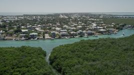 5K aerial stock footage of flying low over mangroves toward Tavernier Creek homes, Tavernier, Florida Aerial Stock Footage | AX0025_090