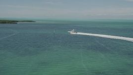 5K aerial stock footage of following a fishing boat speeding past mangroves, Tavernier, Florida Aerial Stock Footage | AX0025_095E