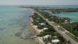 5K aerial stock footage of flying by homes along the coast, Overseas Highway, Islamorada, Florida Aerial Stock Footage | AX0025_128