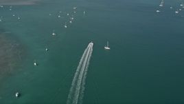 5K aerial stock footage of following a speedboat racing past moored sailboats, Key West, Florida Aerial Stock Footage | AX0026_083