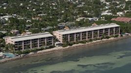 5K aerial stock footage of flying by apartment buildings on the shore of Key West, Florida Aerial Stock Footage | AX0026_116