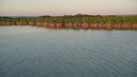 5K aerial stock footage of flying low over water, approaching mangroves and flying over at sunset, Islamorada, Florida Aerial Stock Footage | AX0028_027
