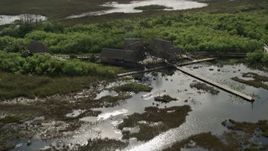 5K aerial stock footage of orbiting huts and dock on marshland, Florida Everglades, Florida Aerial Stock Footage | AX0030_061E