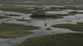 5K aerial stock footage of tracking a fanboat racing through marshland, Florida Everglades, Florida Aerial Stock Footage | AX0030_063