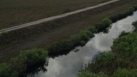 5K aerial stock footage fly over marshland, reveal river, country road, Florida Everglades, Florida Aerial Stock Footage | AX0030_099