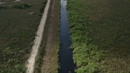 5K aerial stock footage of following river, country road through Florida Everglades, Florida Aerial Stock Footage | AX0030_103