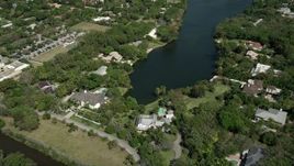 5K aerial stock footage approach residential neighborhood, tilt down to shore of lake, Coral Gables, Florida Aerial Stock Footage | AX0031_002