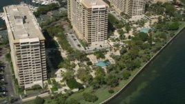 5K aerial stock footage of flying by condo complexes with pools, Grove Isle, Florida Aerial Stock Footage | AX0031_017
