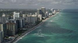 5K aerial stock footage of following beach, approaching condominium complex, Hallandale Beach, Florida Aerial Stock Footage | AX0031_089