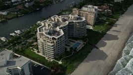 5K aerial stock footage of following the beach, tilt down to condominium complex, Hillsboro Beach, Florida Aerial Stock Footage | AX0032_011