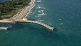 5K aerial stock footage of approaching a pier by Boynton Beach Inlet, tilt down, Boynton Beach, Florida Aerial Stock Footage | AX0032_055