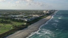 5K aerial stock footage of flying along the coast by apartment buildings, Juno Beach, Florida Aerial Stock Footage | AX0032_127