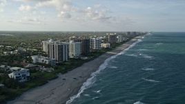 5K aerial stock footage of following the beach, approaching condominium complexes, Juno Beach, Florida Aerial Stock Footage | AX0032_128
