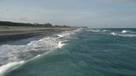 5K aerial stock footage fly over Atlantic Ocean, revealing waves lapping the beach, Hobe Sound, Florida Aerial Stock Footage | AX0032_149E