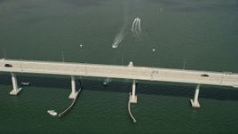 5K aerial stock footage of following speedboats near a bridge in the Indian River, Stuart, Florida Aerial Stock Footage | AX0033_007