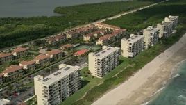 5K aerial stock footage of following the beach blue waters toward vacation rentals, Jensen Beach, Florida Aerial Stock Footage | AX0033_018