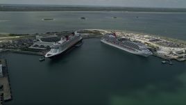 5K aerial stock footage of approaching a Disney and Carnival Cruise Ship, Port Canaveral, Florida Aerial Stock Footage | AX0034_018
