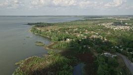 5K aerial stock footage tilt from shore to reveal and approach homes by Lake Apopka, Florida Aerial Stock Footage | AX0035_112E