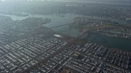 5K aerial stock footage tilt from a bird's eye view of urban neighborhoods to reveal bridges spanning the East River in Queens, New York City, winter Aerial Stock Footage | AX0065_0040E