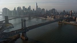 5K aerial stock footage flyby the Manhattan Bridge with a view of the Lower Manhattan skyline and the Brooklyn Bridge, New York City, winter Aerial Stock Footage | AX0065_0145