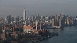 5K aerial stock footage of Empire State Building and Midtown Manhattan skyline seen from power plant by East River, New York City, winter Aerial Stock Footage | AX0065_0159E