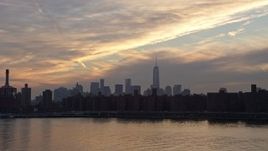 5K aerial stock footage of Lower Manhattan skyline seen while flying low over East River by Stuyvesant Town, New York City, winter, sunset Aerial Stock Footage | AX0065_0168
