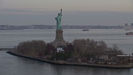 5K aerial stock footage of flying around the back of the Statue of Liberty and Liberty Island in New York, winter, twilight Aerial Stock Footage | AX0065_0185E
