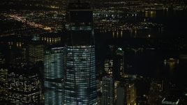 5K aerial stock footage orbit and tilt up the side of One World Trade Center skyscraper in Lower Manhattan, New York City, winter, night Aerial Stock Footage | AX0065_0297E
