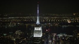 5K aerial stock footage of orbiting the top of the Empire State Building in Midtown Manhattan, New York City, winter, night Aerial Stock Footage | AX0065_0321E