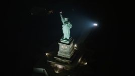 5K aerial stock footage of a slow approach to the Statue of Liberty in New York, winter, night, tilt to bird's eye view Aerial Stock Footage | AX0065_0392E