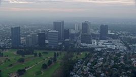 7.6K aerial stock footage flying over golf course along office buildings and skyscrapers, sunrise, Century City, California Aerial Stock Footage | AX0156_132