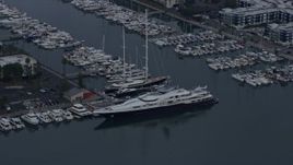 7.6K aerial stock footage pulling away from a docked mega yacht with helicopter, sunrise, Marina Del Rey, California Aerial Stock Footage | AX0156_177