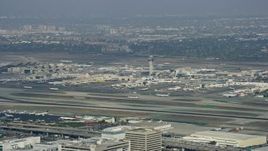 7.6K aerial stock footage tracking a plane taking off from LAX, cloudy, Los Angeles, California Aerial Stock Footage | AX0157_004