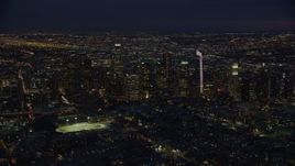 7.6K aerial stock footage approaching skyscrapers lit up for the night in Downtown Los Angeles, California Aerial Stock Footage | AX0158_074