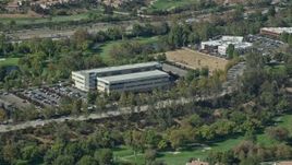7.6K aerial stock footage orbiting an office building and parking lot next to a golf course, Valencia, California Aerial Stock Footage | AX0159_030E