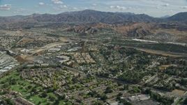 7.6K aerial stock footage of suburban housing and an interchange with mountains in the distance, Santa Clarita, California Aerial Stock Footage | AX0159_050E