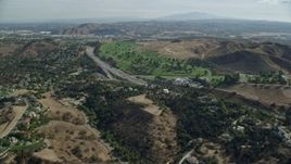 7.6K aerial stock footage following the I-10 freeway between homes and Forest Lawn Covina Hills Cemetery, Covina, California Aerial Stock Footage | AX0159_130E