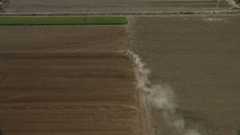 7.6K aerial stock footage of a truck creating dust trail in farmland, Chino, California Aerial Stock Footage | AX0159_150