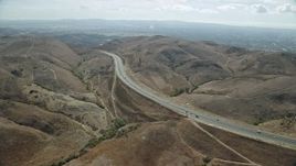 7.6K aerial stock footage following a freeway with light traffic through the hills, Irvine, California Aerial Stock Footage | AX0159_162E