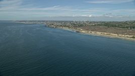 7.6K aerial stock footage flying along coast over blue ocean waters toward Pelican Point, Newport Beach, California Aerial Stock Footage | AX0159_231E