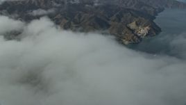 7.6K aerial stock footage flying over clouds to reveal Avalon, Catalina Island, California Aerial Stock Footage | AX0159_250E