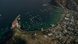 7.6K aerial stock footage of a reverse view of the harbor and the coastal town of Avalon, Catalina Island, California Aerial Stock Footage | AX0159_253E