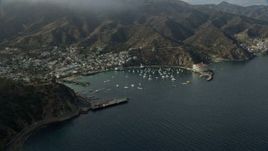 7.6K aerial stock footage of a reverse view of boats anchored in Avalon Bay in Avalon, Catalina Island, California Aerial Stock Footage | AX0159_257
