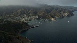 7.6K aerial stock footage flying away from the harbor and the island town of Avalon, Santa Catalina Island, California Aerial Stock Footage | AX0159_258E