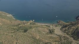 7.6K aerial stock footage of a reverse view of a campground, beach, and sailboats on the coast of Santa Catalina Island, California Aerial Stock Footage | AX0159_269