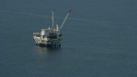 7.6K aerial stock footage of an oceanic oil derrick off the coast of Southern California Aerial Stock Footage | AX0160_037E