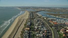7.6K aerial stock footage over beachfront homes and highway to approach Seal Beach National Wildlife Refuge, Huntington Beach, California Aerial Stock Footage | AX0160_052E