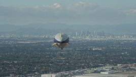 7.6K aerial stock footage of the Goodyear Blimp flying toward Downtown Los Angeles skyline from Long Beach Airport, California Aerial Stock Footage | AX0160_062E