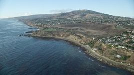 7.6K aerial stock footage tilting from kelp in the ocean to reveal coastal cliffs and neighborhoods in San Pedro, California Aerial Stock Footage | AX0161_017E